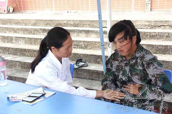 覃秀冬医师正给学生看病